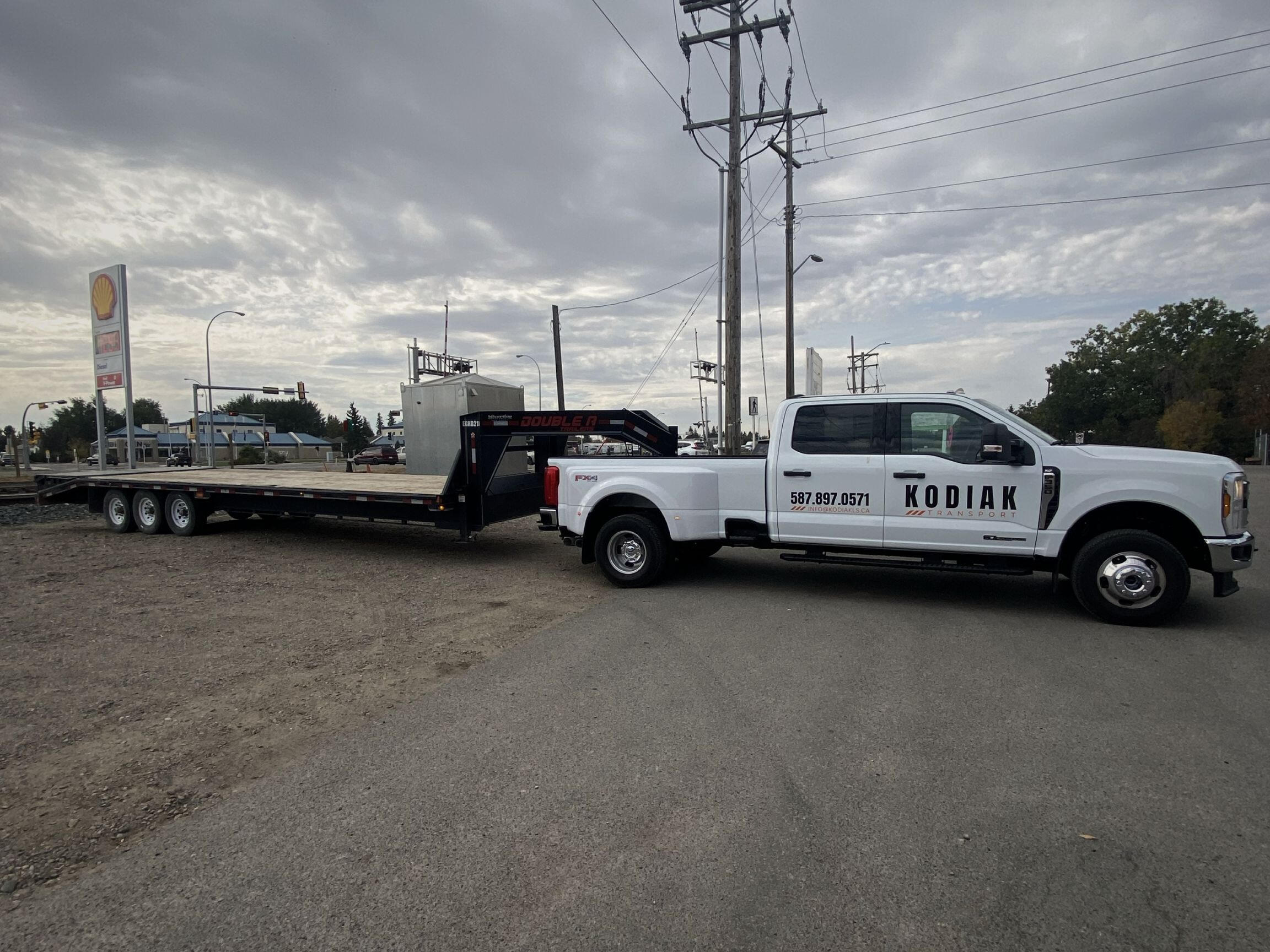 Kodiak Transport gooseneck trailer and F-350 rig parked in Alberta, showcasing heavy-duty hauling setup.